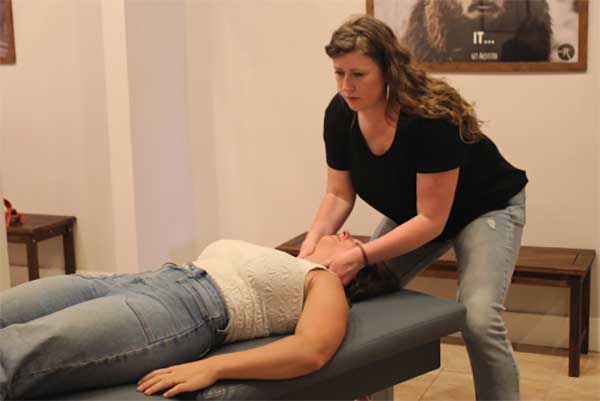 A doctor performing a gentle chiropractic adjustment on a patient lying on the table
