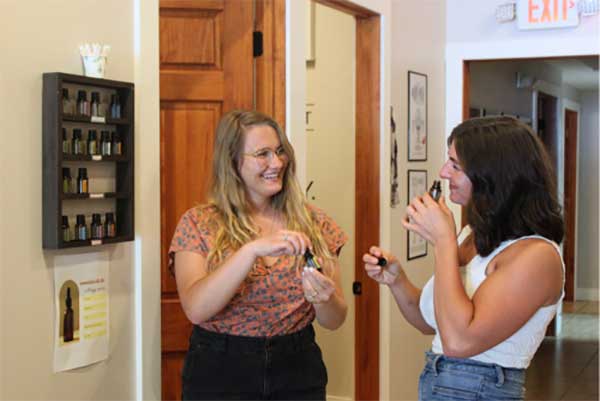 A team member and a patient sampling essential oils during an office tour