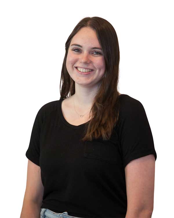 Emily F., chiropractic assistant at Radius Chiropractic, smiling, wearing a black shirt, showcasing her friendly demeanor and commitment to patient care.